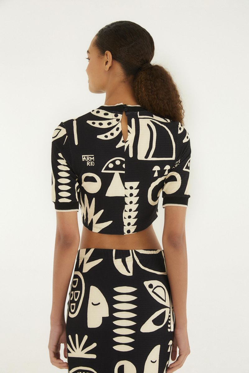 Vista trasera de la blusa cropped con estampado abstracto y abertura en la espalda.