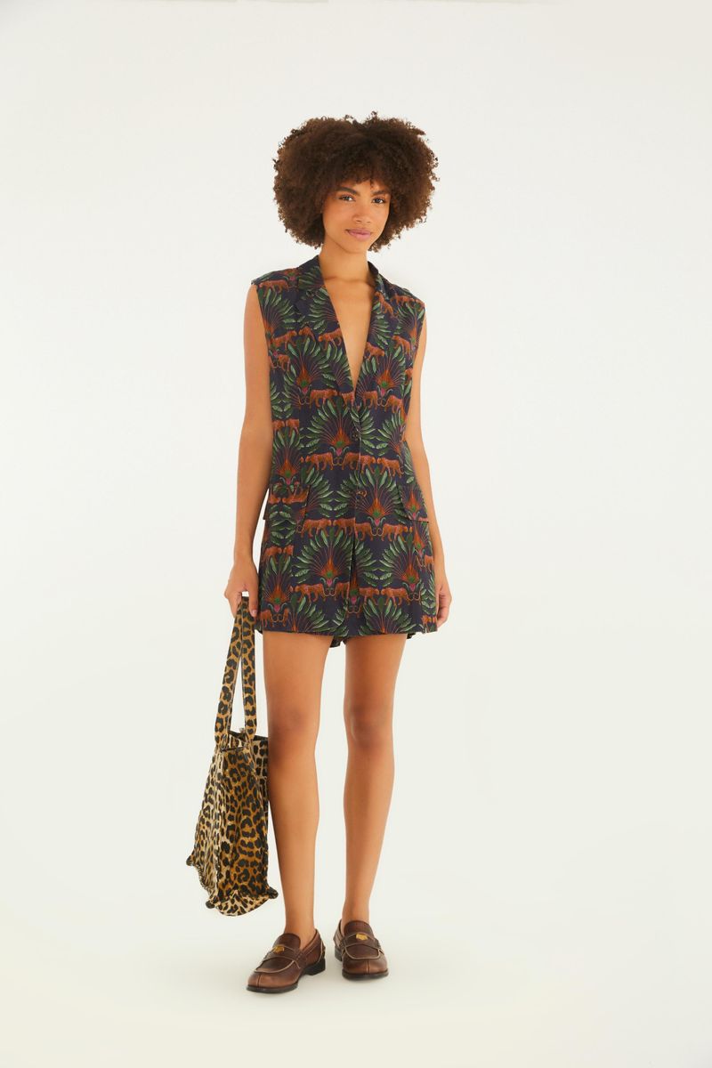 Modelo vistiendo falda estampada tropical con follaje y jaguar, combinada con blusa sin mangas.