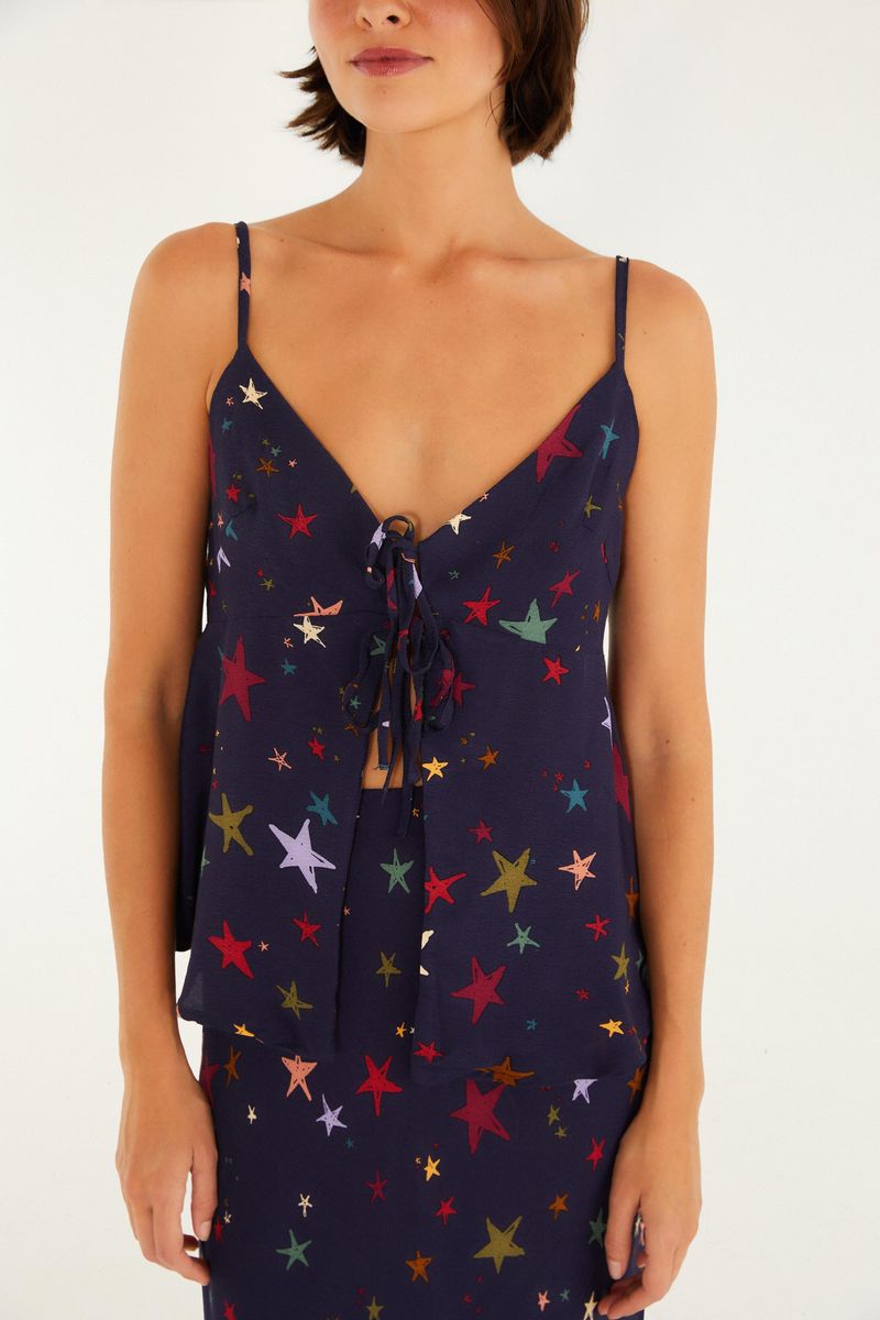 Detalle del escote en V y amarre frontal de la blusa con estampado de estrellas.