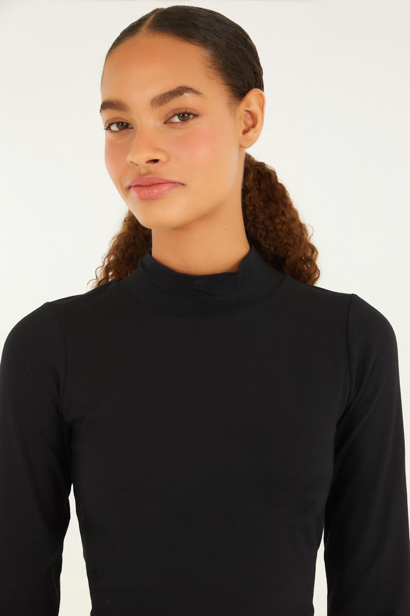 Detalle del cuello alto de la blusa cropped negra.
