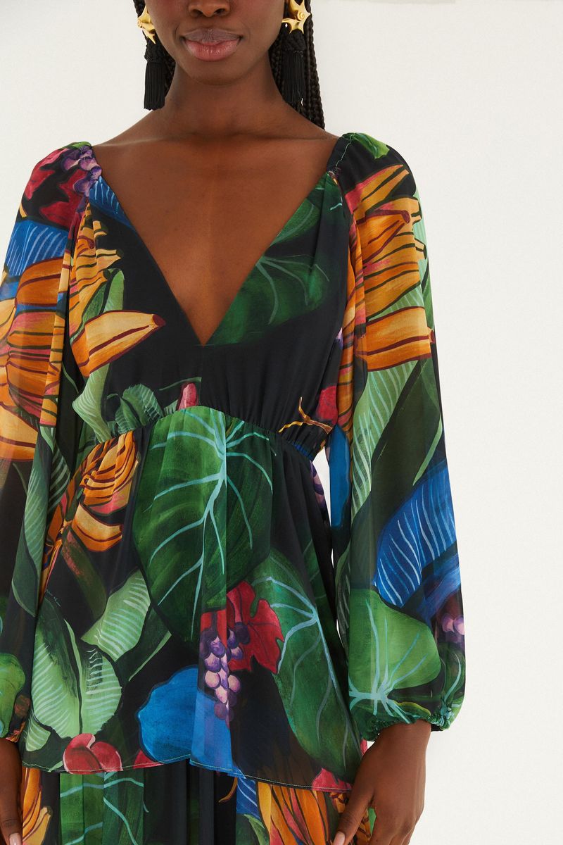 Detalle del vestido largo estampado mostrando el diseño tropical con hojas y flores vibrantes.