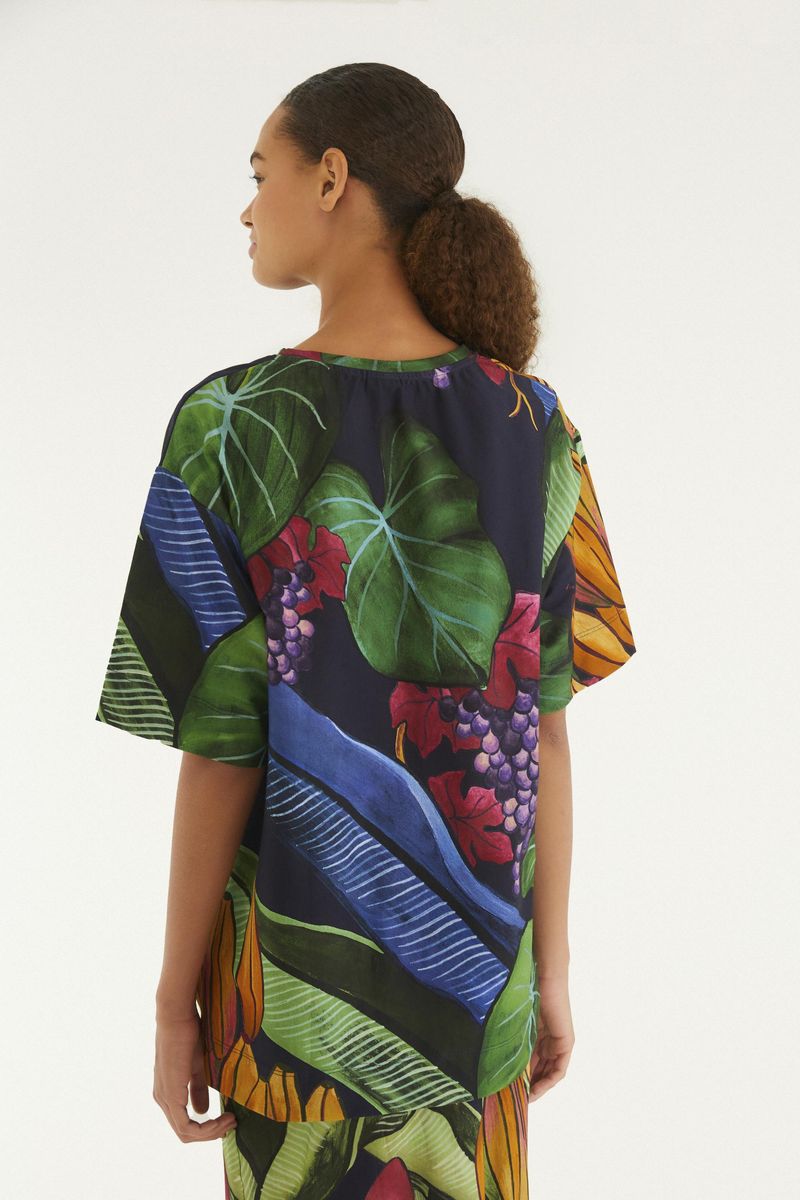 Vista trasera de la camiseta estampada tropical con diseño vibrante.