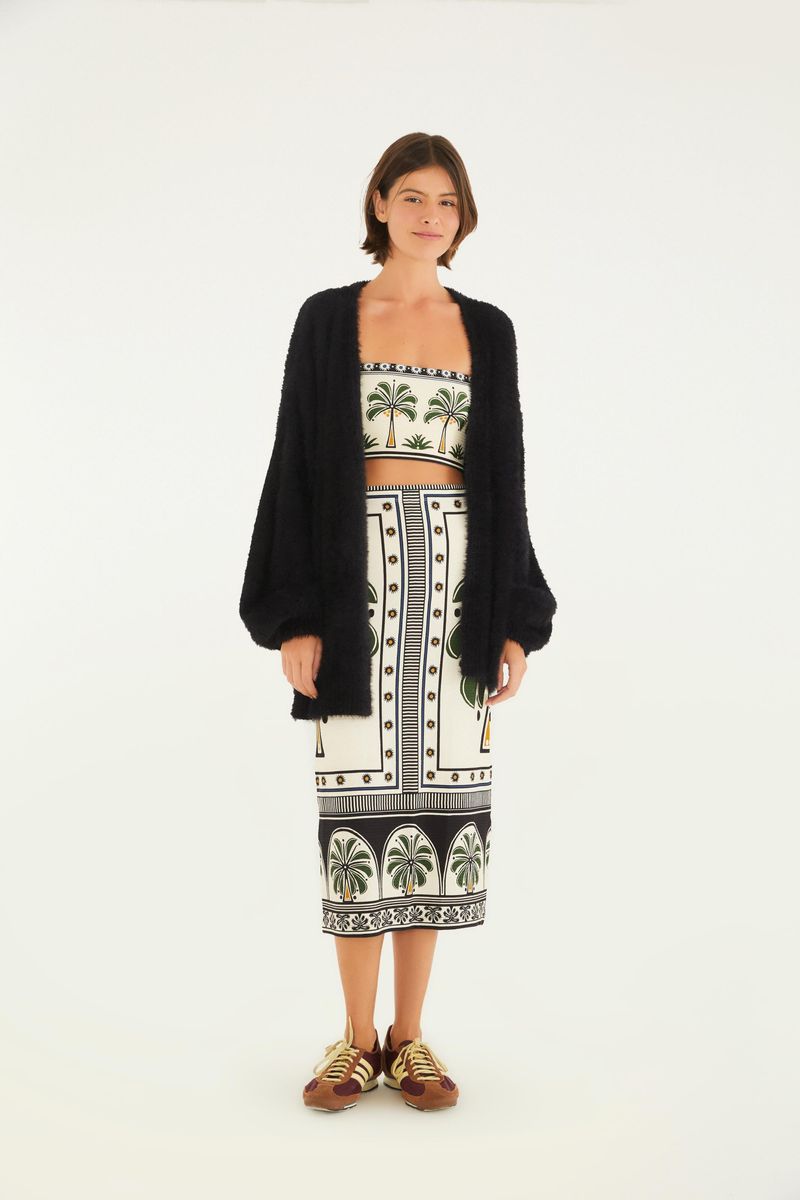 Conjunto con top recto y falda midi estampada, acompañado de cárdigan negro.