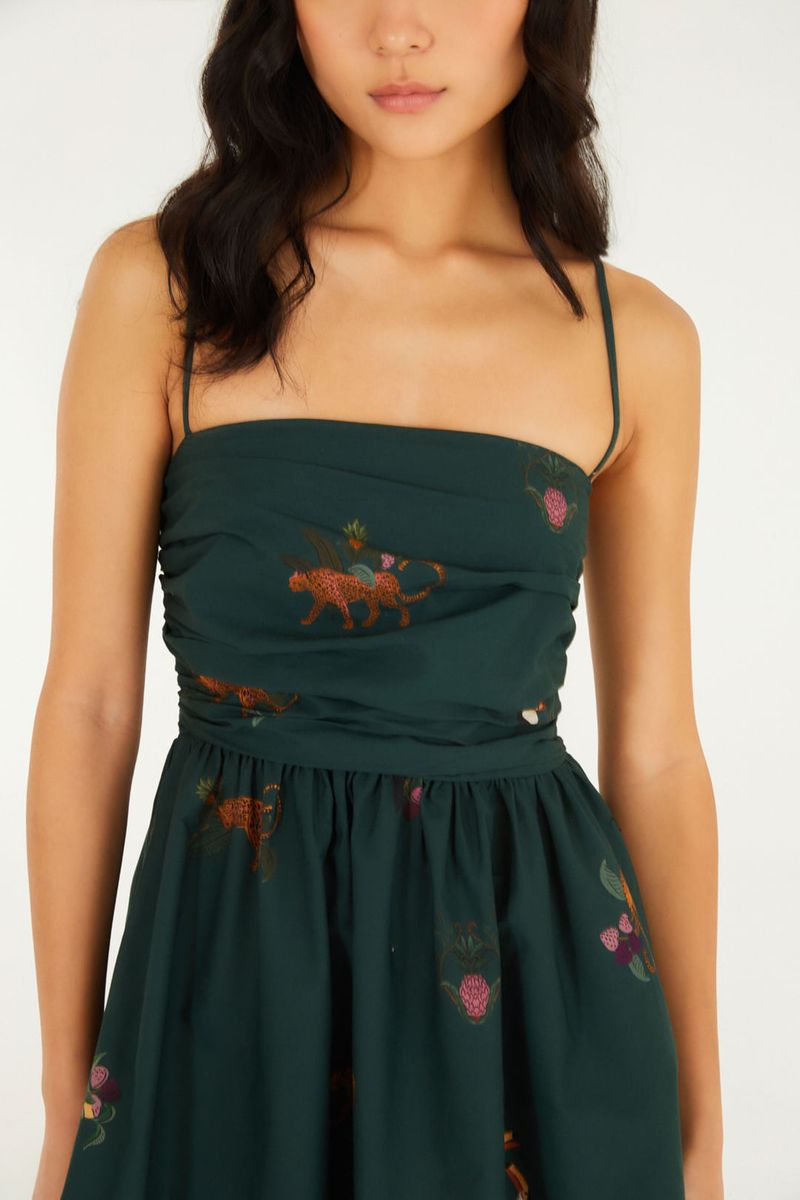 Detalle del vestido corto verde con estampado de animales y flores, mostrando el corsé y los tirantes finos.