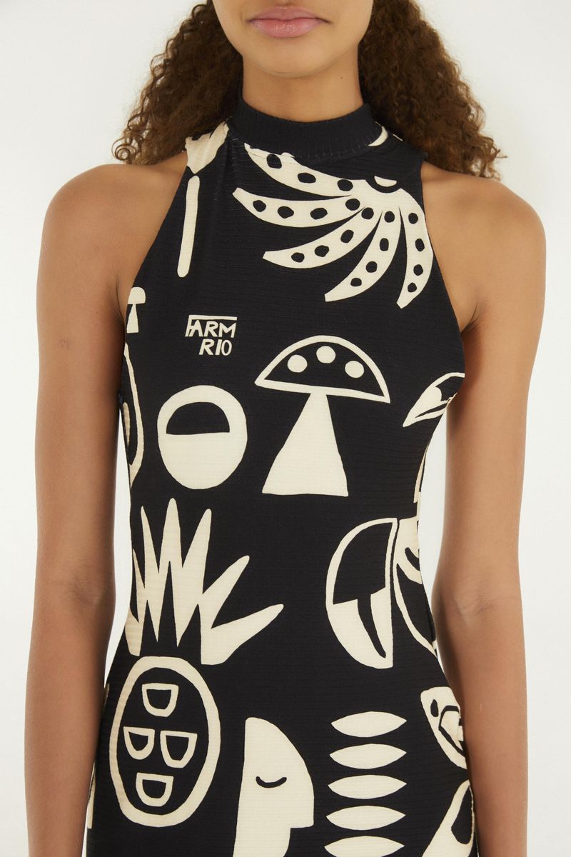 Detalle del vestido midi mostrando el estampado tropical en blanco y negro, con elementos gráficos y cuello alto.