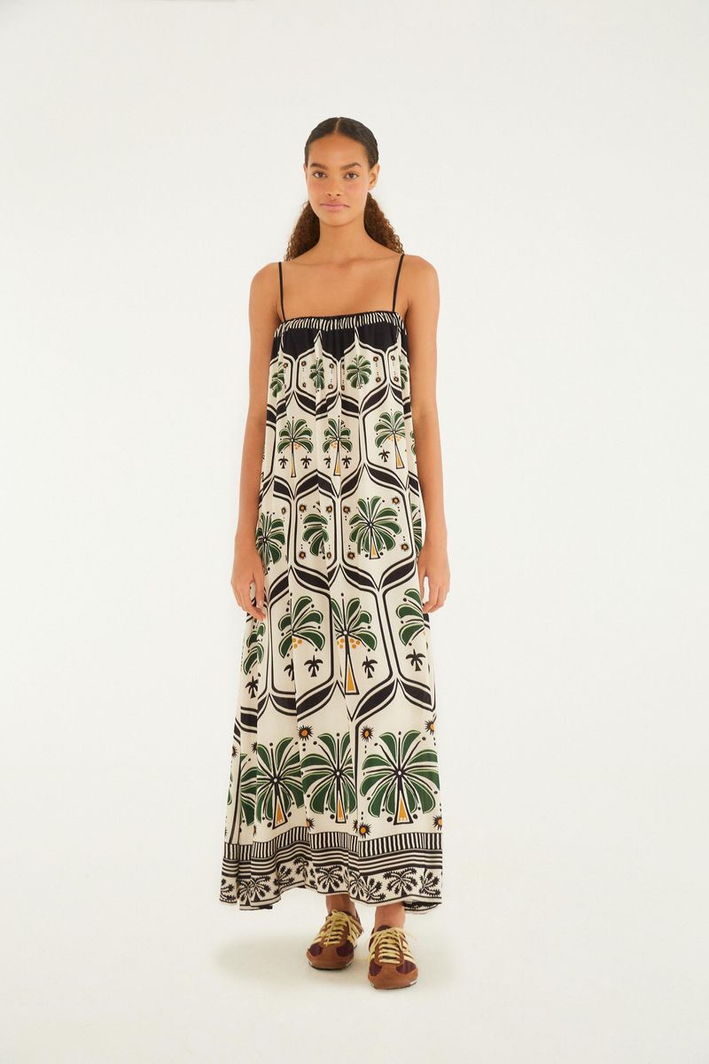 Modelo usando un vestido largo estampado con temática tropical, visto de frente.
