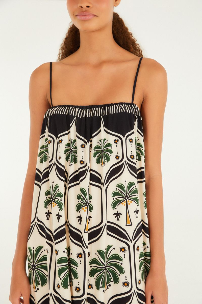 Detalle del escote y las tirantas finas del vestido largo estampado con temática tropical.