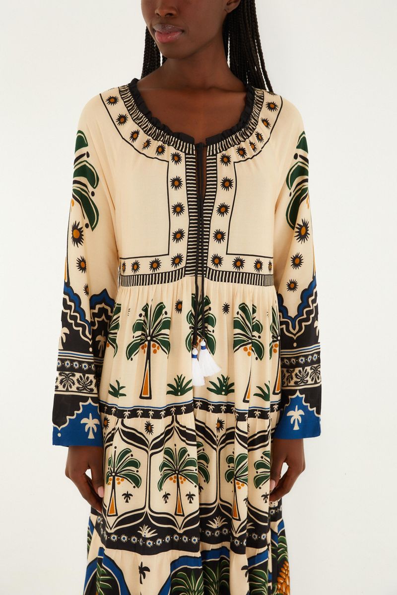 Vista cercana del vestido mostrando el diseño tropical con palmeras y detalles geométricos en la parte superior.