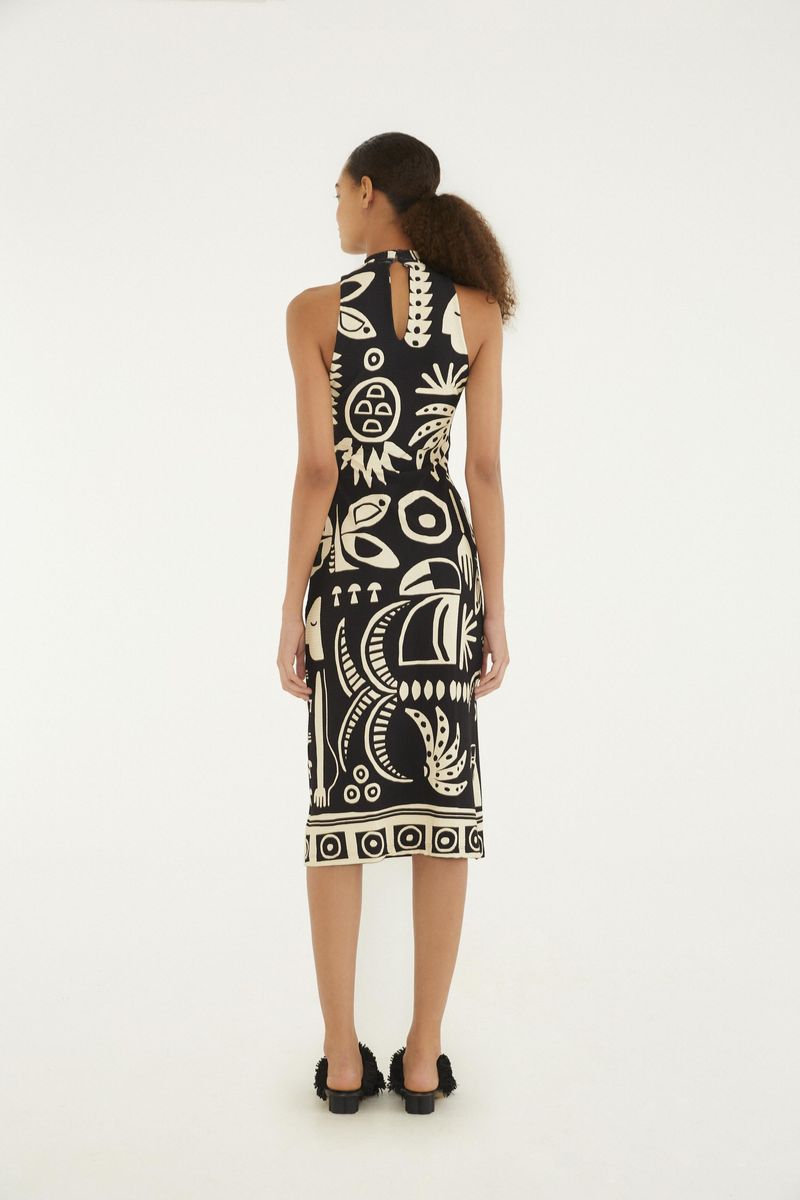 Vista trasera del vestido midi con estampado tropical en blanco y negro, destacando el ajuste al cuerpo y el largo midi.