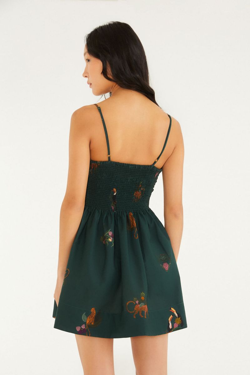 Vista trasera del vestido corto verde con estampado de animales y flores, mostrando el detalle del corsé y los tirantes.
