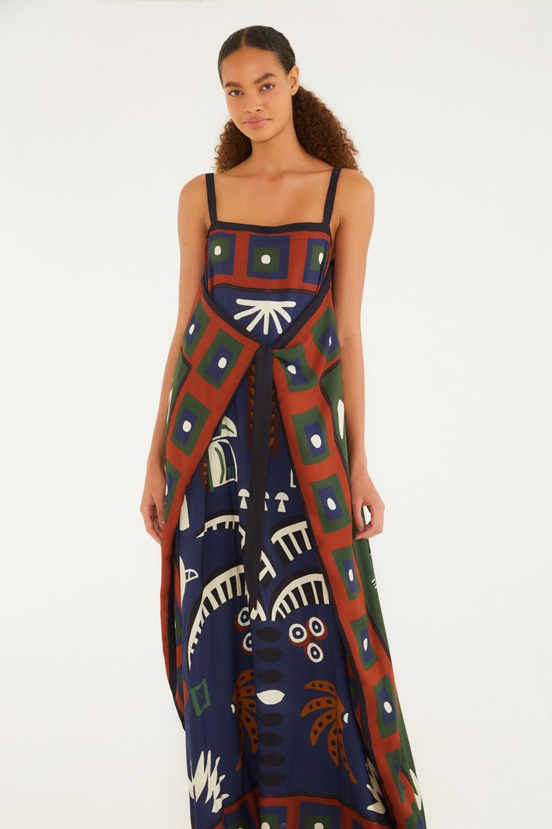Vestido midi con estampado tropical, tirantes delgados y diseño fluido visto de lado.