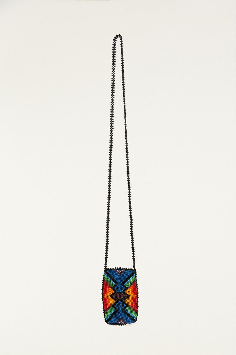 Imagen de una bolsa artesanal con estampado geométrico en abalorios coloridos, vista frontal detallada.