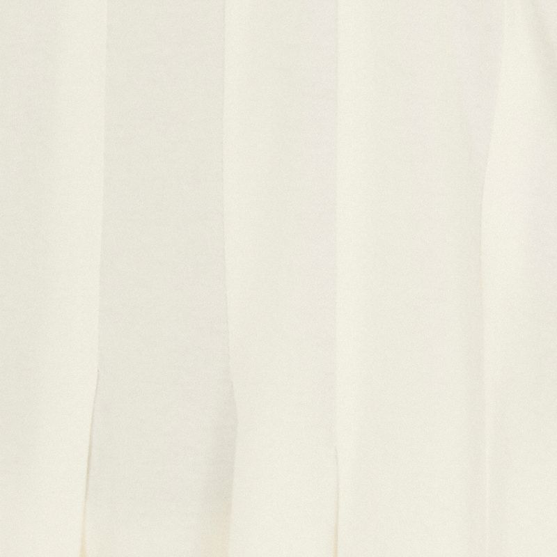 Acercamiento de los pespuntes en la camiseta cropped, destacando la textura del tejido.