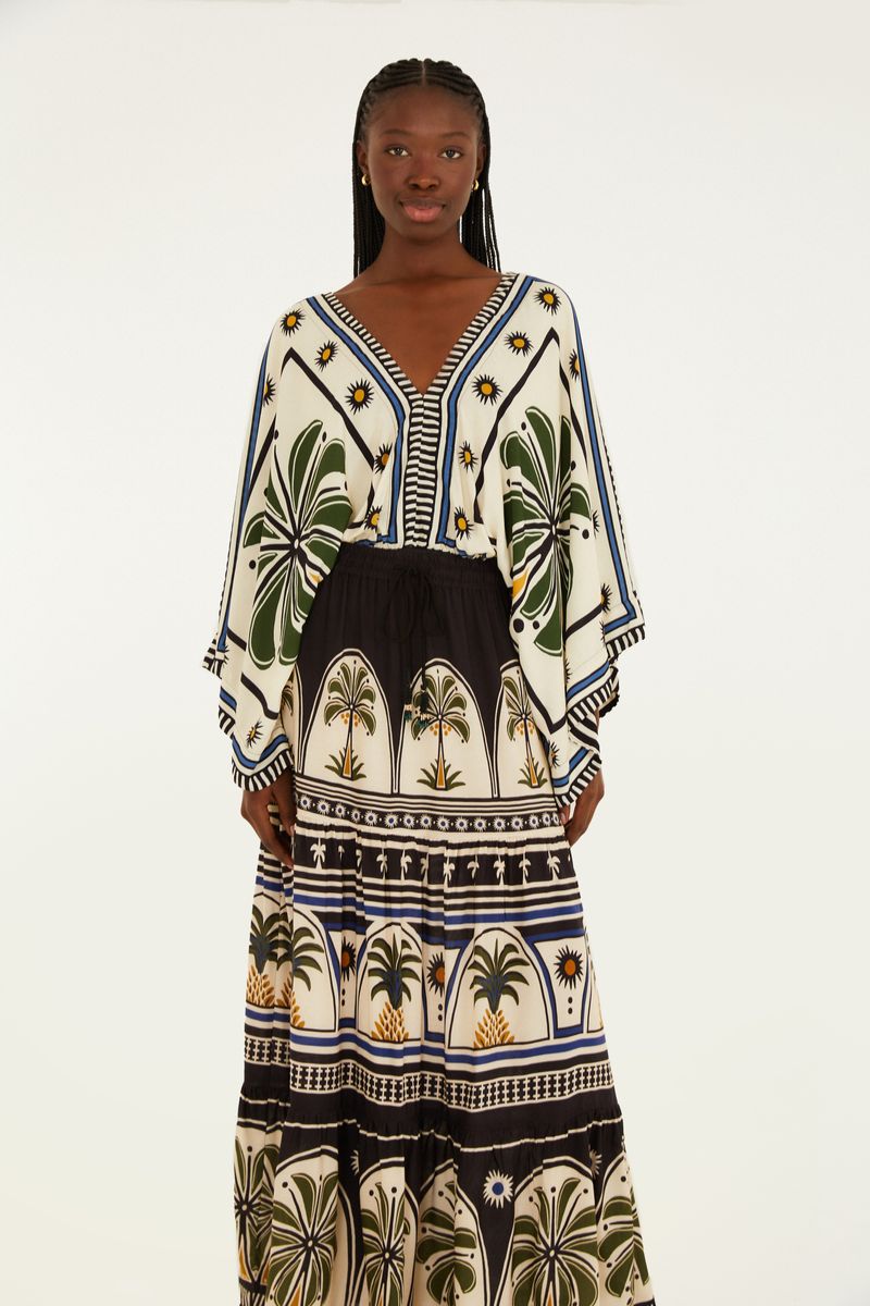 Modelo usando una falda larga con estampado tropical, vista trasera.