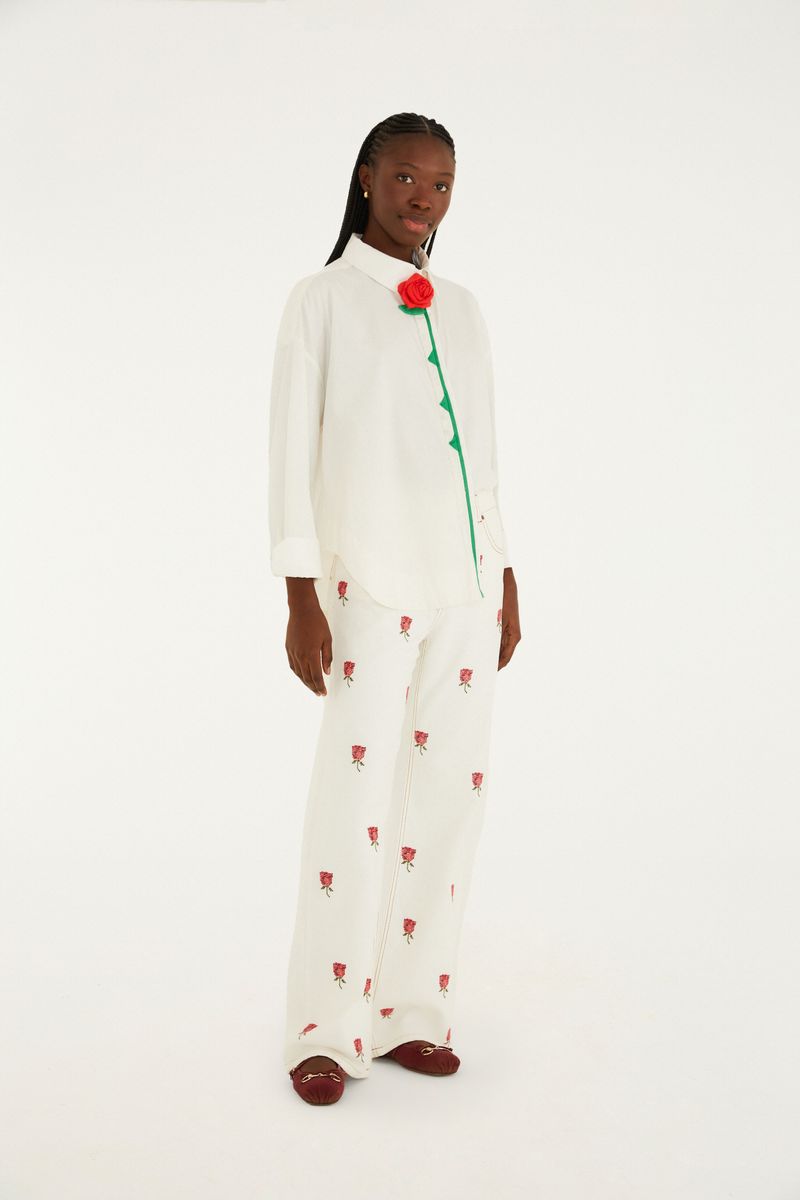 Vista completa de la camisa artesanal blanca con detalles florales y pantalón combinado.