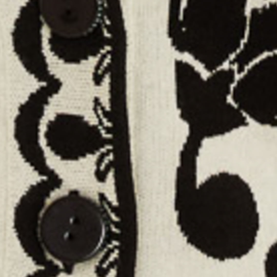 Close-up del estampado floral y arabesco del cardigan largo tejido.