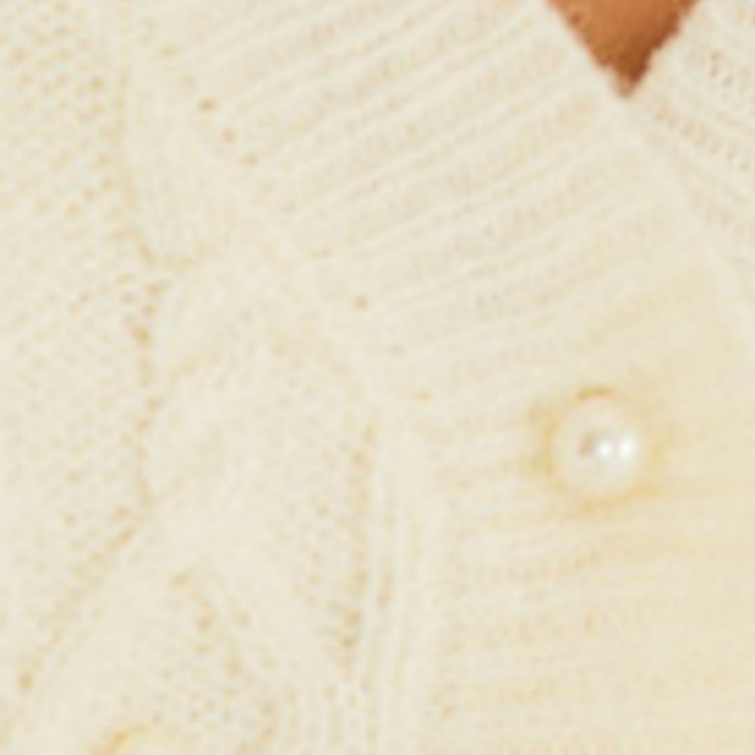 Detalle del bordado en perlas en la blusa de tricot.