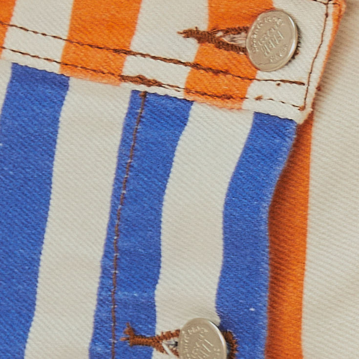 Close-up del botón de la falda pantalón con estampado de rayas.
