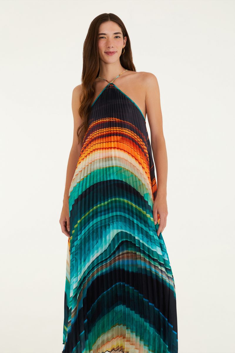 Vestido plisado con estampado vibrante en tonos de azul, naranja y negro, visto de lado.