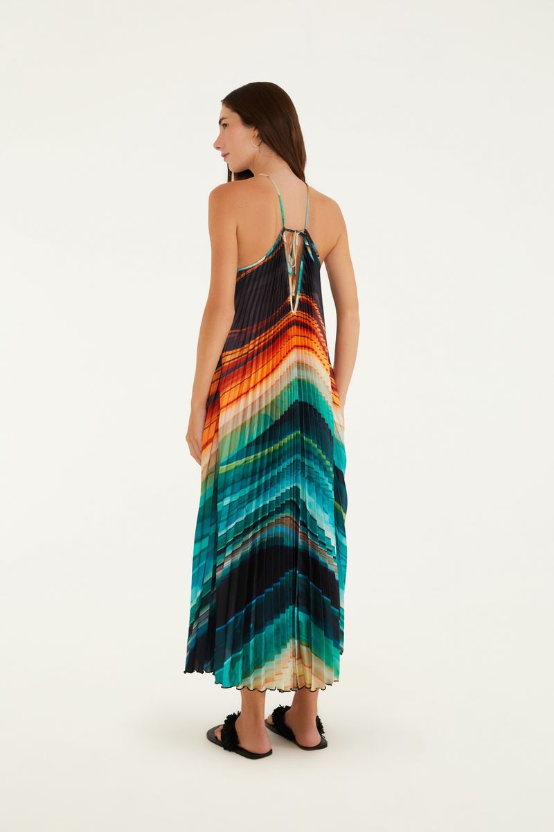 Vestido plisado con estampado vibrante en tonos de azul, naranja y negro, visto de espaldas.