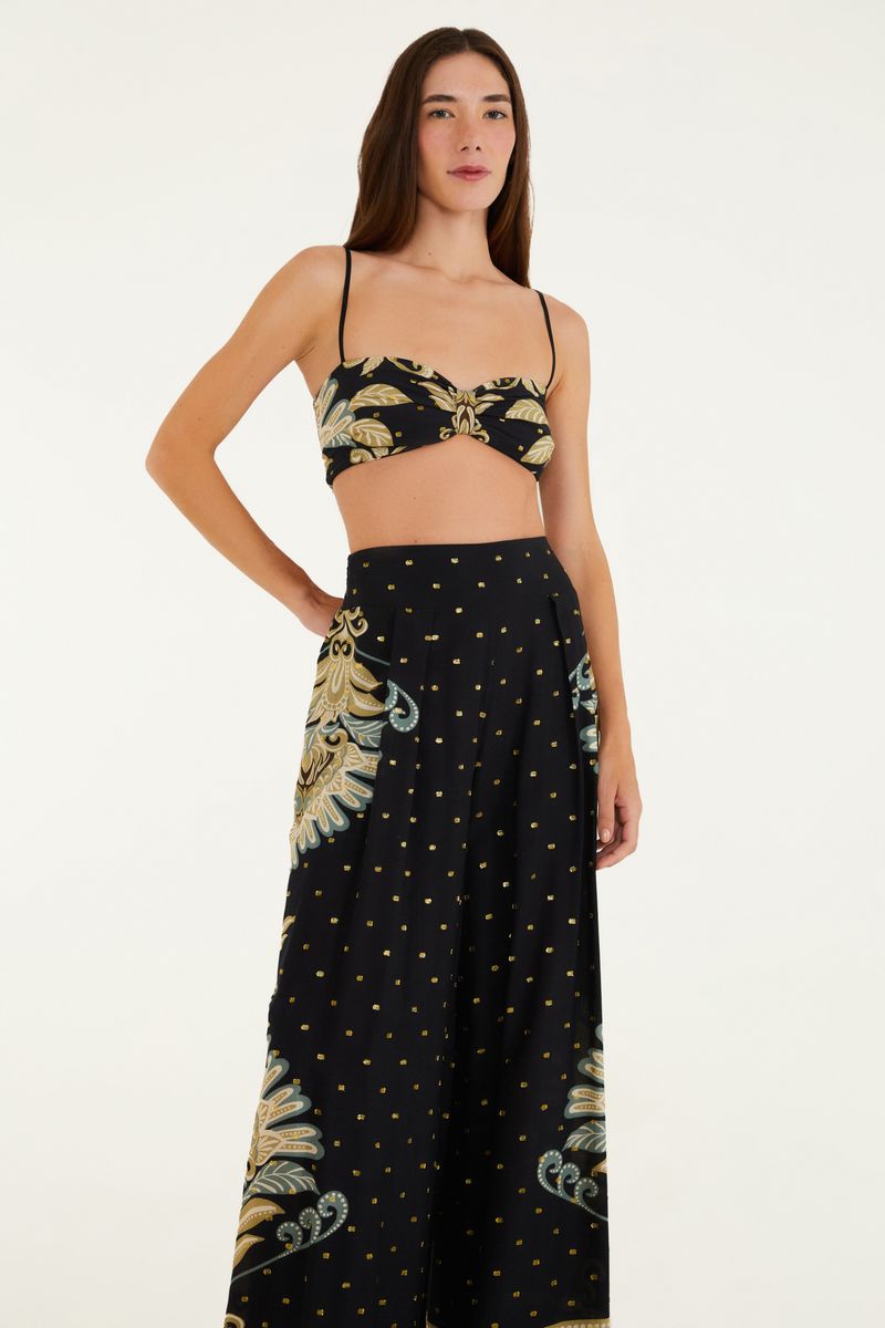 Modelo llevando conjunto de pantalón recto y top estampado, vista trasera.