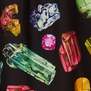 Imagen de una falda larga con estampado de piedras preciosas multicolor, detalle de la parte trasera.