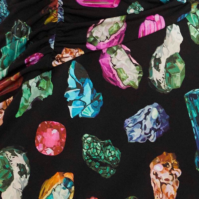Detalle del estampado de piedras preciosas coloridas en la tela del vestido.
