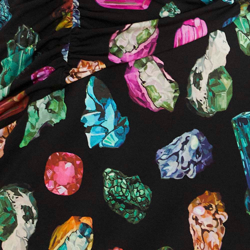 Detalle del estampado de piedras preciosas coloridas en la tela del vestido.