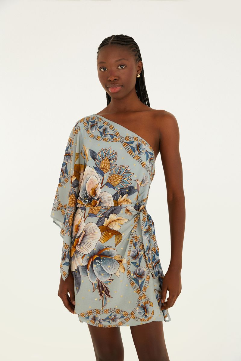 Vestido corto con estampado floral en tonos de azul y amarillo, diseño de un solo hombro y detalle de amarre en la cintura.