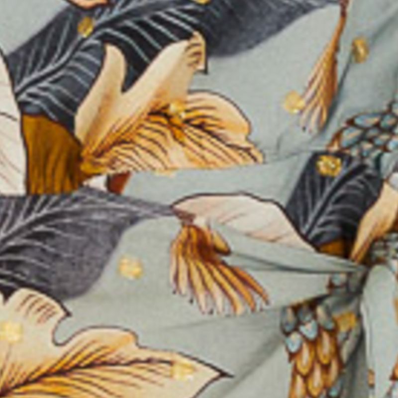 Detalle del estampado floral del vestido, con elementos botánicos en tonos vibrantes.