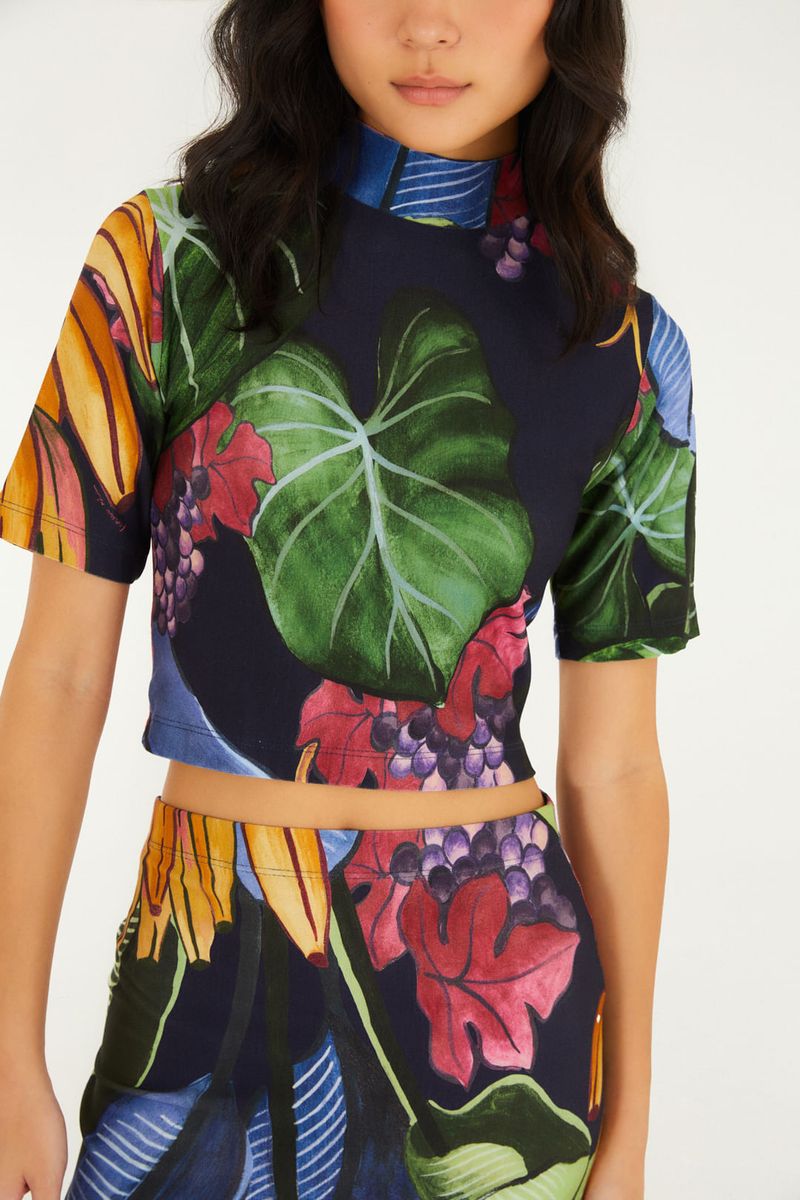Detalle del estampado tropical en la blusa cropped, con bananas y uvas.