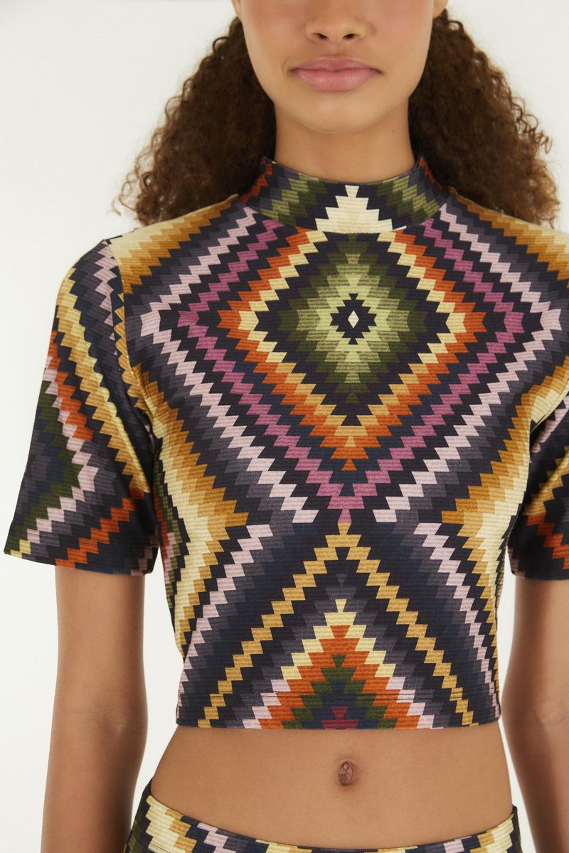 Detalle del cuello alto de la blusa cropped con estampado geométrico.