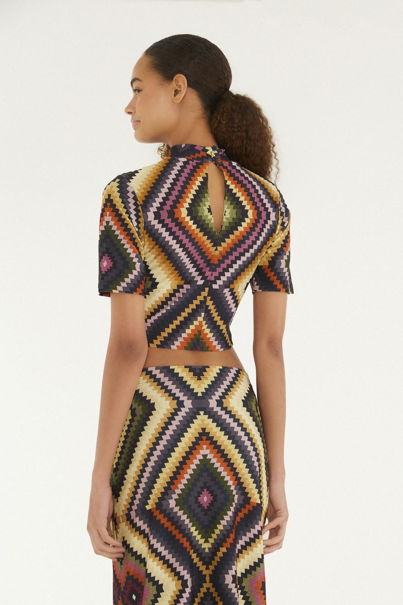 Vista trasera de la blusa cropped con apertura y estampado geométrico.