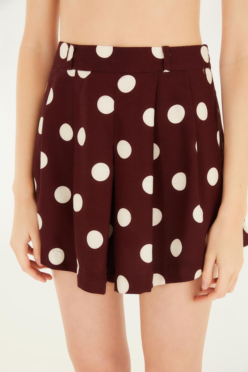 Detalle de la falda mostrando el estampado de lunares y la pretina alta.