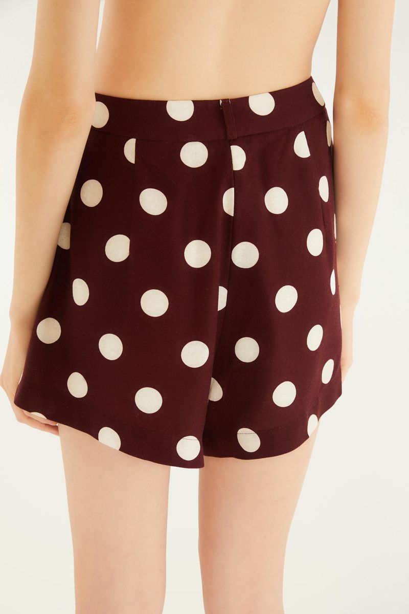 Vista trasera de la falda con estampado de lunares sobre fondo vino.