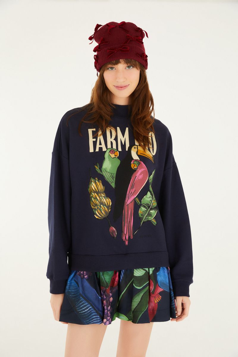 Imagen frontal de un vestido de moletón con estampado de frutas y animales, mostrando detalles del diseño.