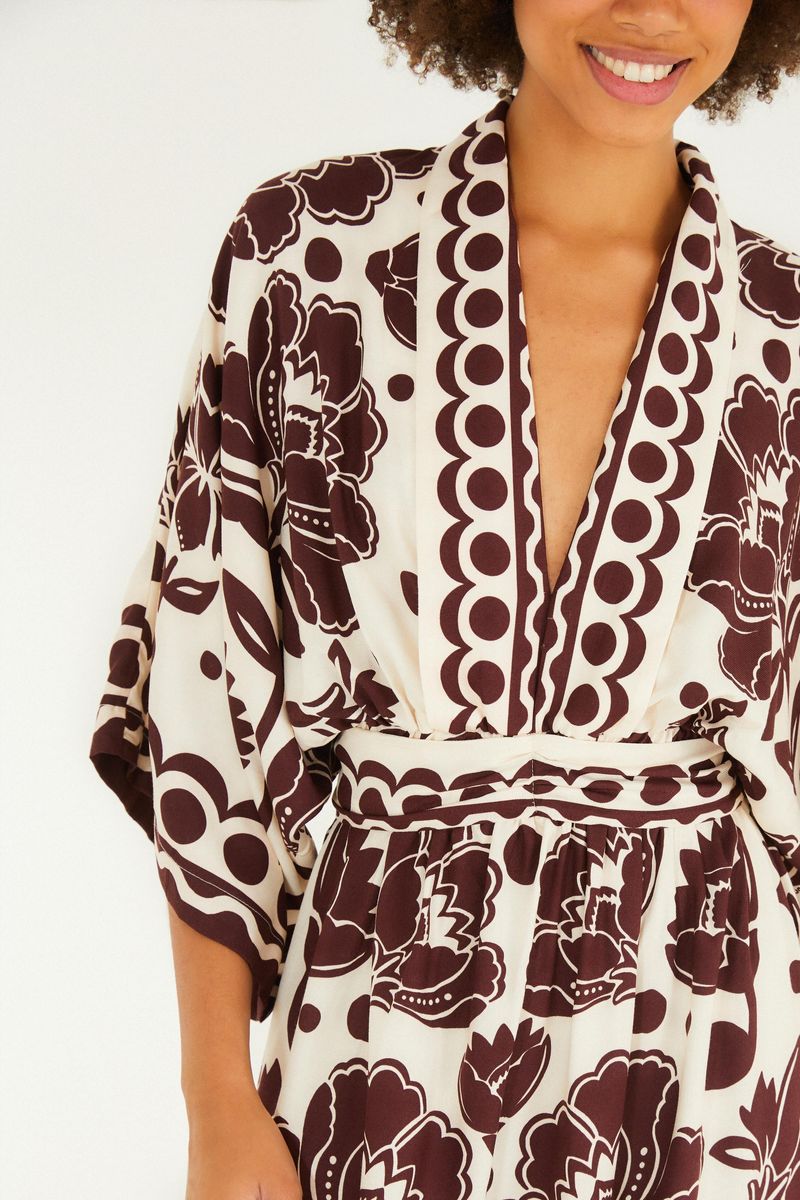 Detalle del escote en V de vestido largo con diseño floral arabesco.