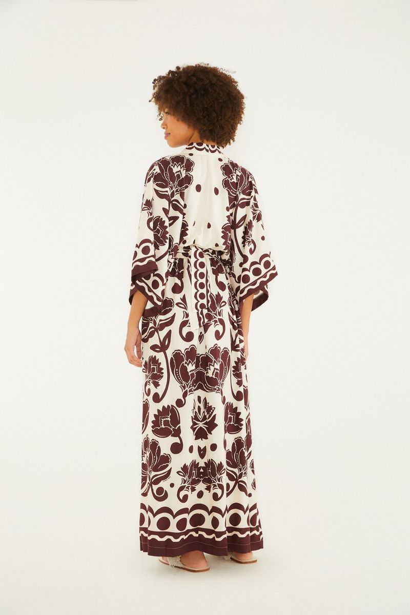 Vista lateral del vestido largo con diseño floral arabesco que resalta las mangas anchas y el caído.