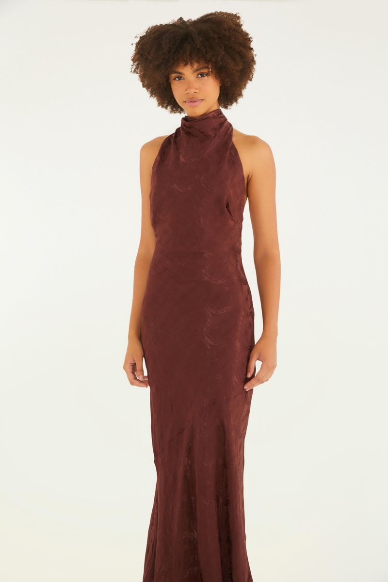 Vestido largo en tejido jacquard con cuello alto y detalle de lazada en la espalda, visto de perfil.