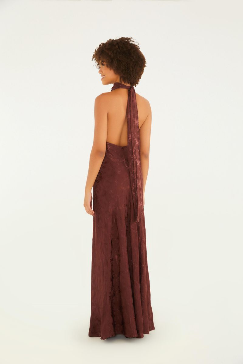 Detalle del tejido jacquard del vestido largo con cuello alto y lazada en la espalda.