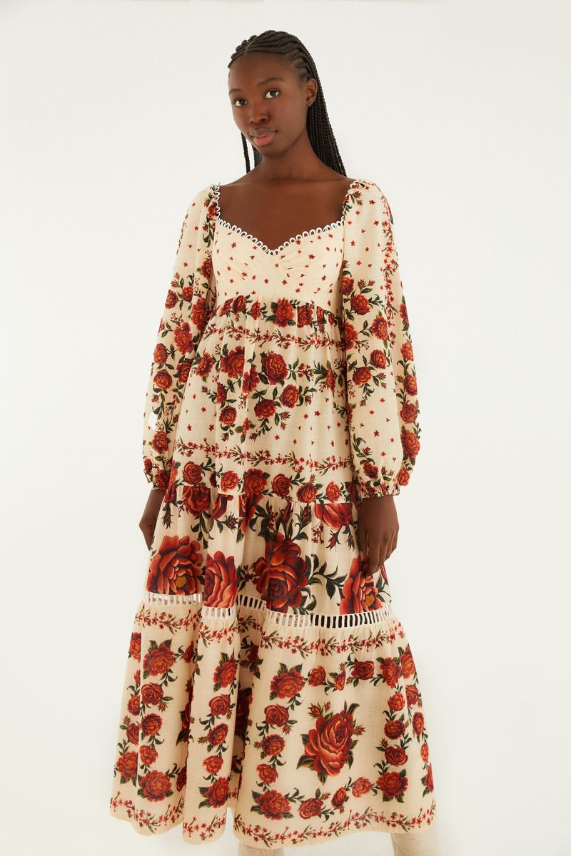 Imagen lateral del vestido destacando las mangas largas y el patrón floral.