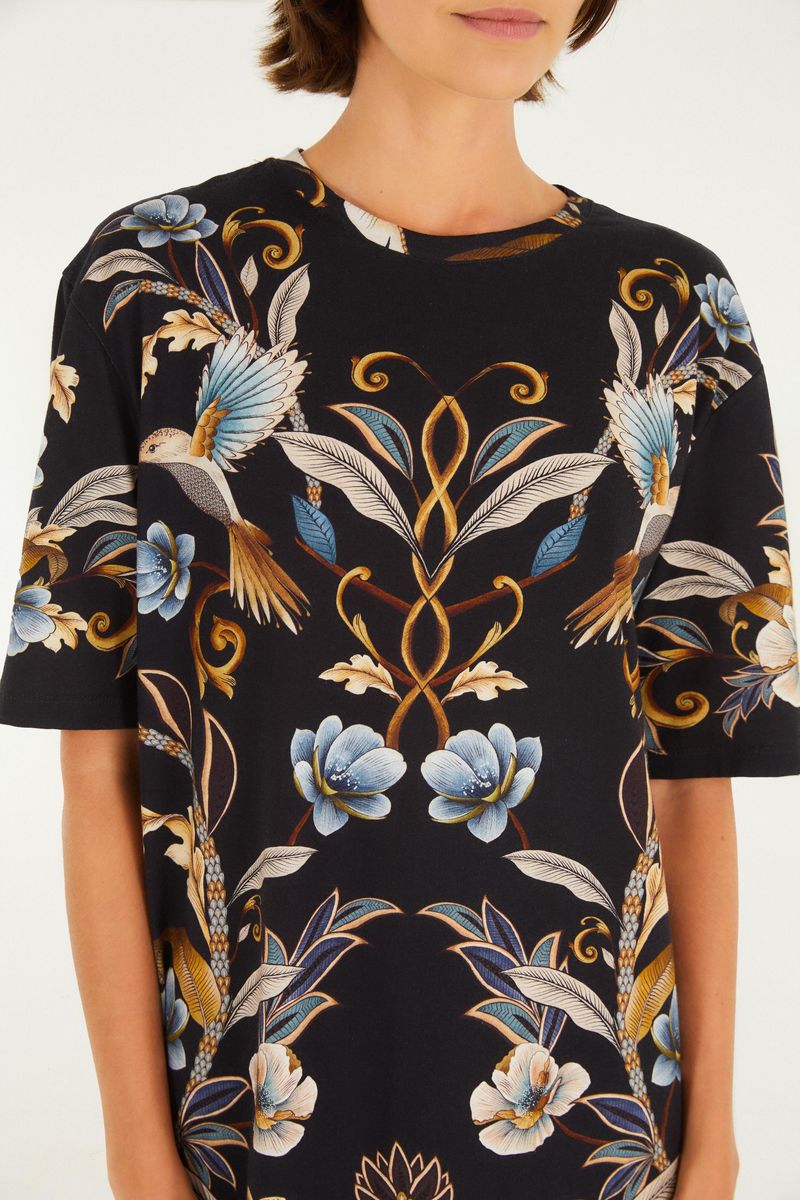 Vista trasera del vestido con estampado floral y botánico en fondo negro.