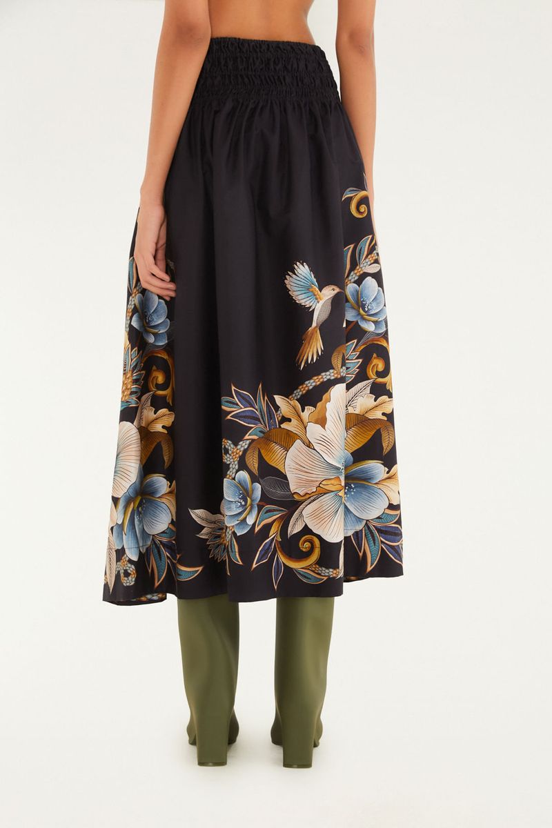Vista lateral de la falda corta con estampado floral vibrante, mostrando detalles de la cintura elástica.