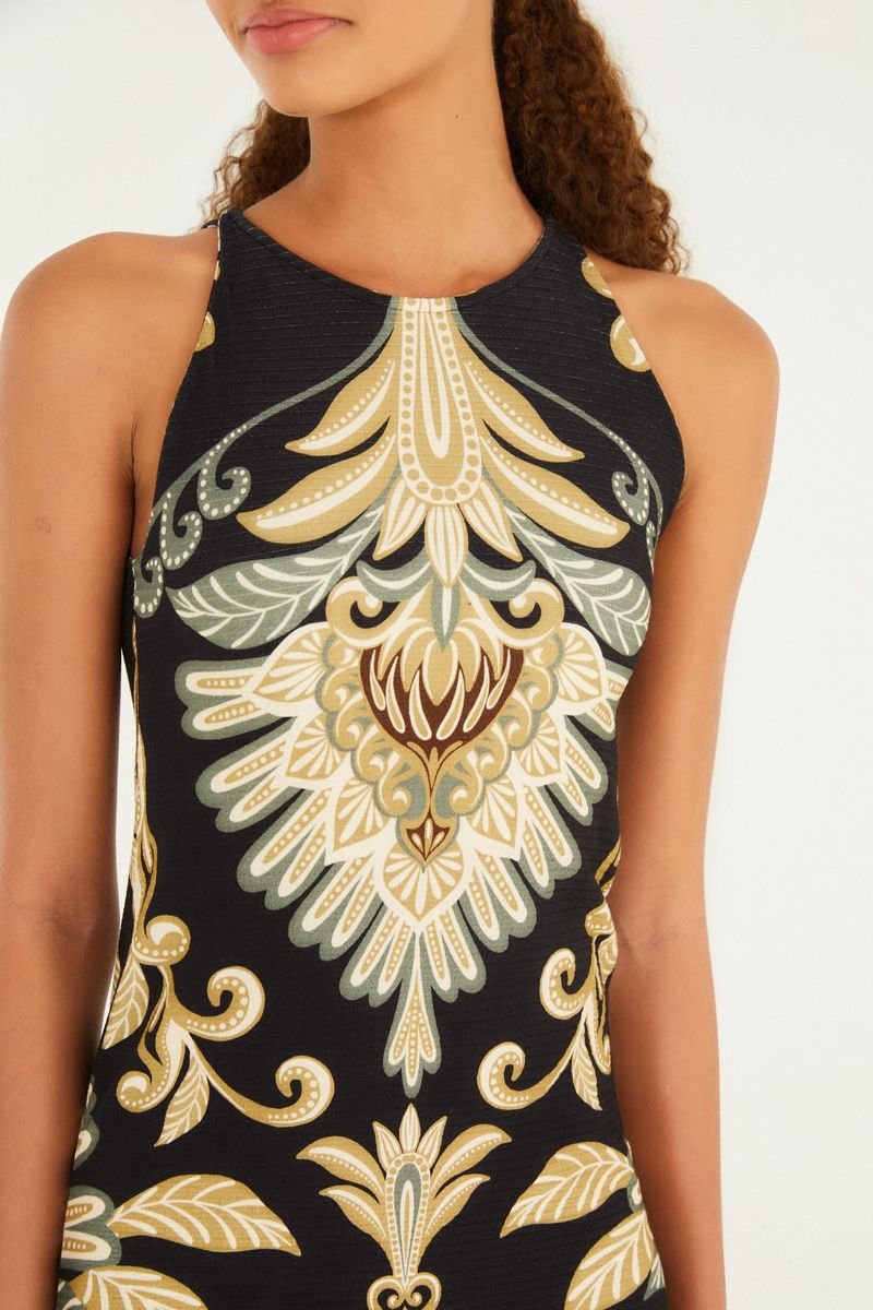 Detalle del escote del vestido midi estampado con diseño geométrico y floral en tonos negro, dorado y verde.
