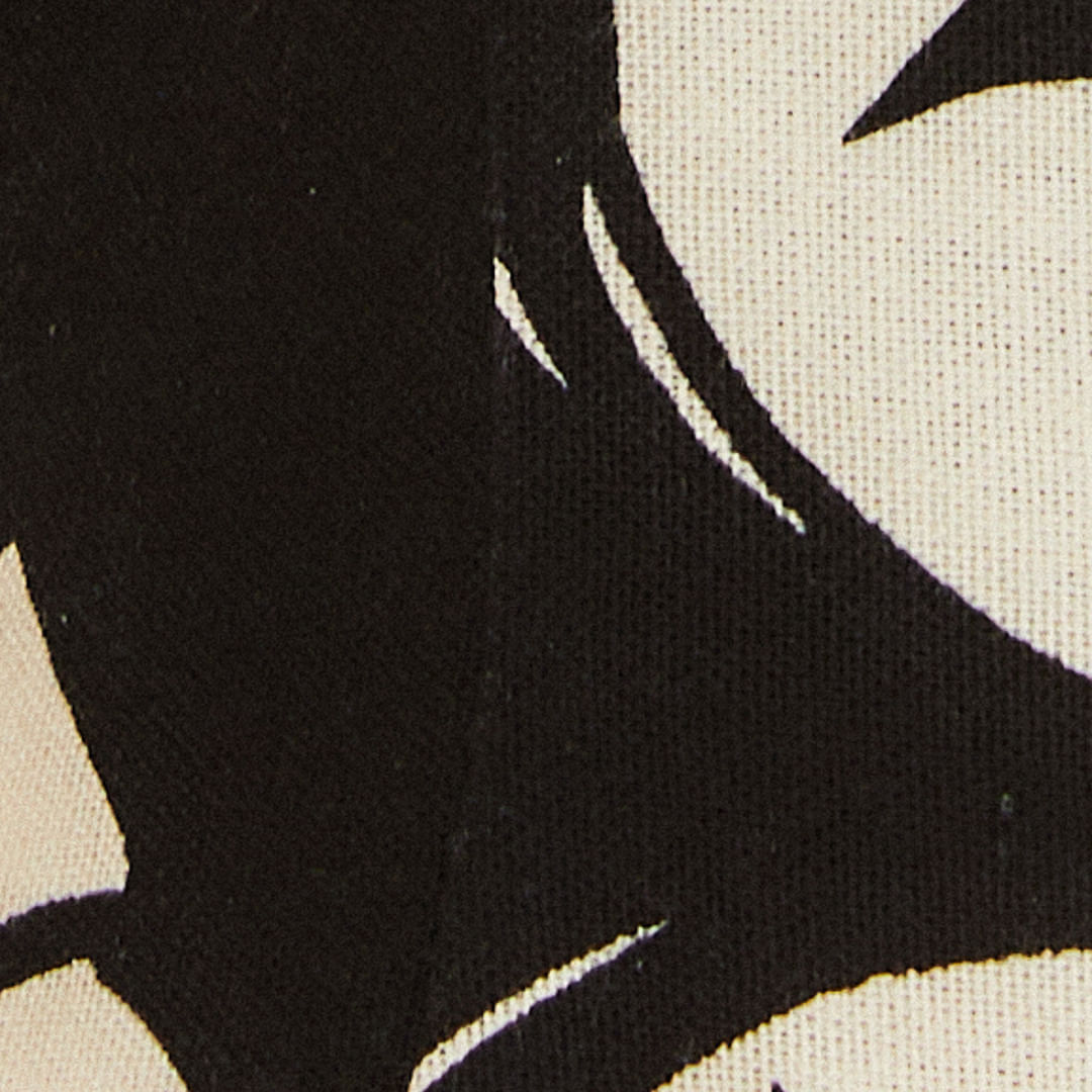 Primer plano de tela con un patrón abstracto en negro y beige, destacando la textura y detalles del diseño.
