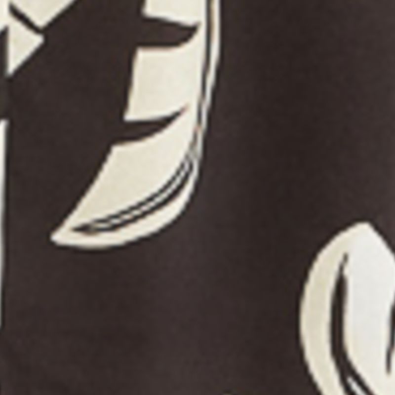 Imagen mostrando un detalle de la tela del vestido con diseño de hojas de palmera estilizadas sobre fondo oscuro.
