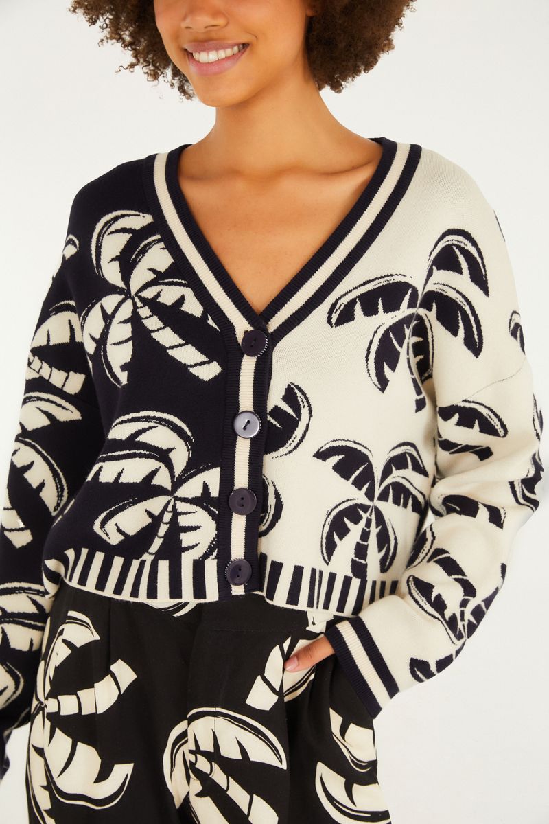 Detalle del cardigan corto de tricot con estampado tropical, destacando el patrón.