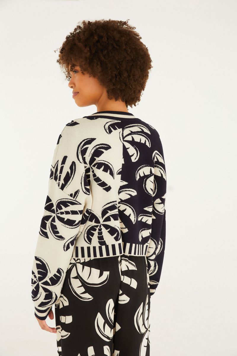 Vista lateral del cardigan corto de tricot con estampado tropical, mostrando el diseño.