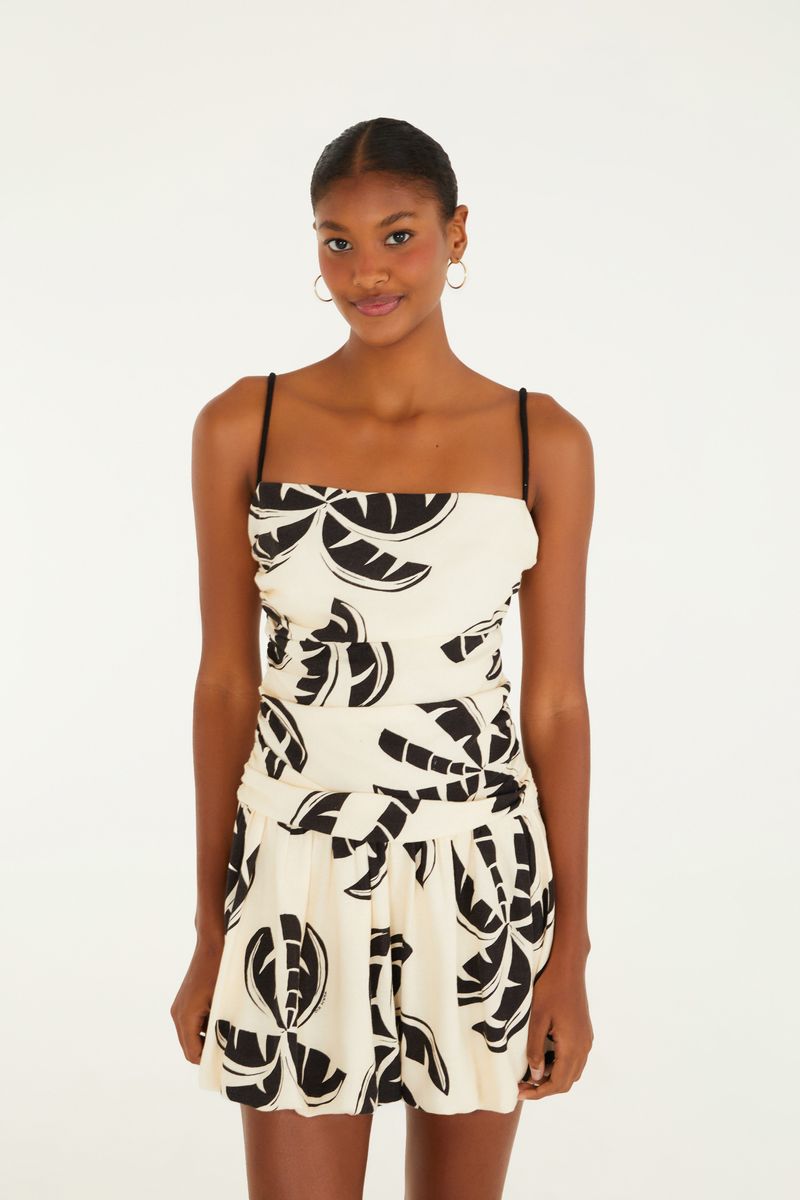 Imagen frontal de un vestido corto con estampado de hojas en blanco y negro, con tirantes finos y detalle en la cintura.