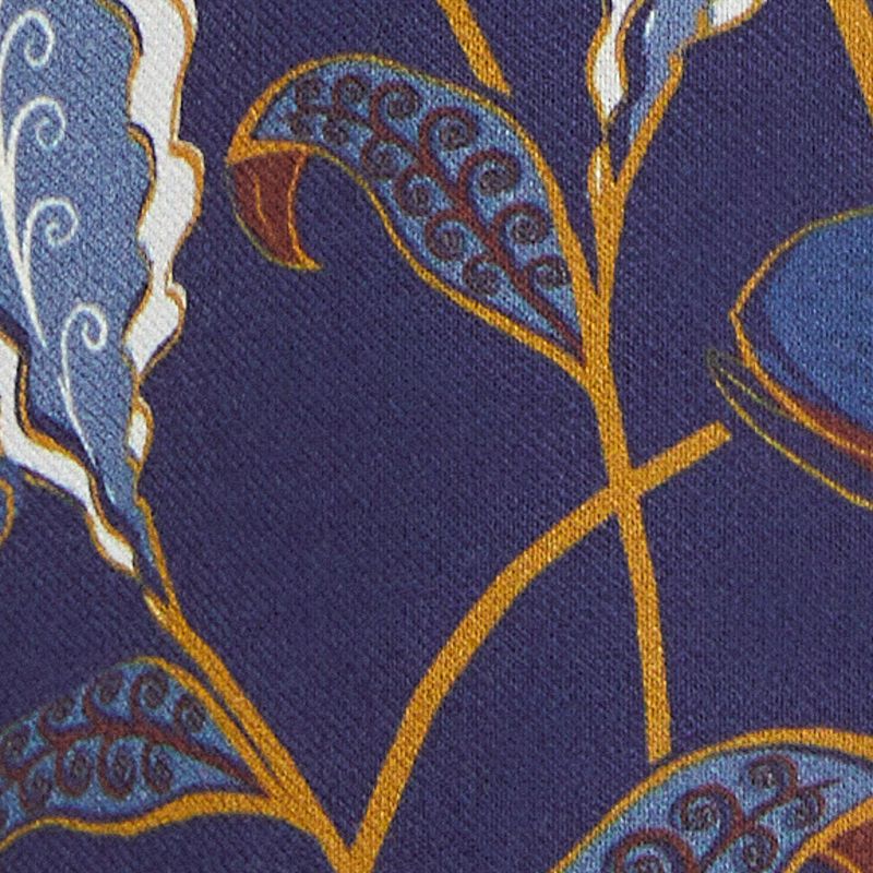 Acercamiento del estampado floral y botánico del vestido, con elementos en azul, verde y amarillo.